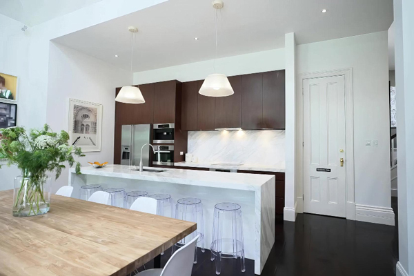 A cozy kitchen with a wooden table and chairs, inviting you to sit and enjoy a meal together.