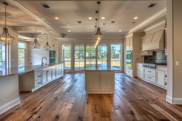 Spacious kitchen with hardwood floors and white cabinets.